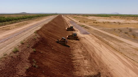 Wide-drone-shot-of-building-a-dirt-wall-or-border-for-a-rock-quarry