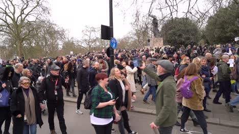 Large-crowds-marching-holding-signs-at-the-anti-lockdown-protest-in-London,-UK