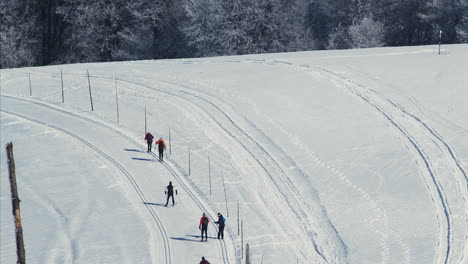 Vista-Aérea-De-Seis-Personas-Esquiando-Cuesta-Arriba-En-Un-Impresionante-Paisaje-Nevado-De-Invierno