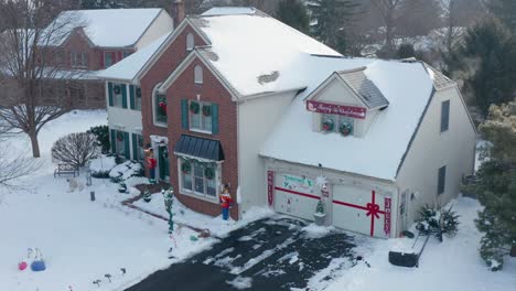 Antena-Del-Exterior-Delantero-De-La-Casa-Cubierta-De-Nieve,-Decorada-Para-Navidad