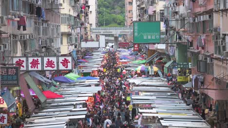 Clip-Inclinado-De-Los-Puestos-Del-Mercado-De-La-Calle-Fa-Yuen-Mientras-Grandes-Multitudes-De-Compradores-Buscan-Verduras,-Frutas,-Regalos-Y-Artículos-De-Moda-A-Precio-De-Ganga-En-Hong-Kong