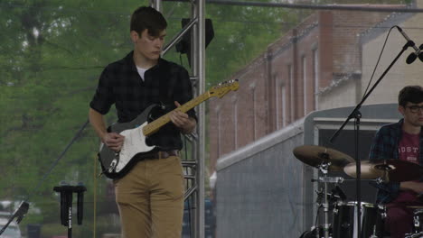 Guitar-player-at-a-concert-at-Dogwood-Festival,-Siloam-Springs,-AR,-wide-shot