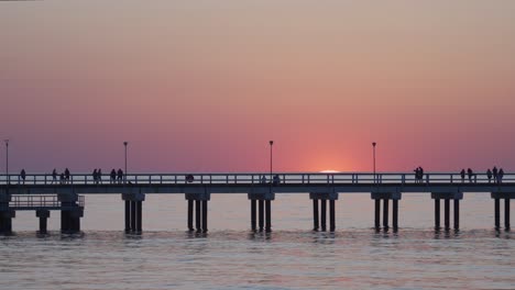 Timelapse-De-La-Puesta-De-Sol-En-El-Mar-Báltico-Con-Gente-Caminando-En-El-Muelle-De-Palanga