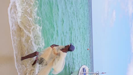 Vertical-slow-motion-shot-of-native-Dominican-fisherman-throwing-net-into-Caribbean-Sea