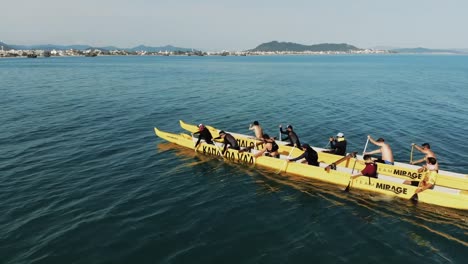 Toma-Aérea-De-Un-Grupo-De-Kayakistas-En-Canoa-Doble-En-El-Océano-Atlántico-En-Santa-Catarina,-Brasil-Durante-El-Día-Soleado