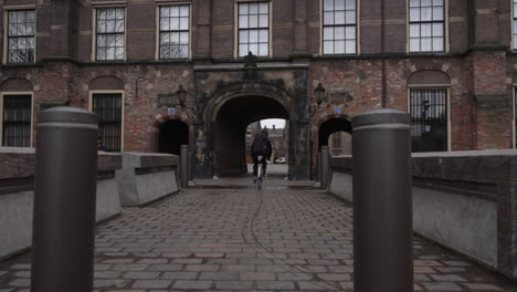 Un-Ciclista-Entra-Por-La-Puerta-Del-Binnenhof-En-La-Haya,-4k