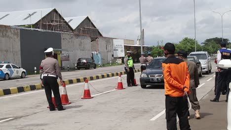 Agentes-De-Seguridad-De-La-Policía-Nacional-Indonesia-Y-Las-Fuerzas-Armadas-Interceptan-Vehículos-Que-Salen-De-La-Carretera-De-Peaje,-Para-Comprobar-Si-Hay-Transmisión-De-Covid-19,-Pekalongan,-17-De-Junio-De-2021