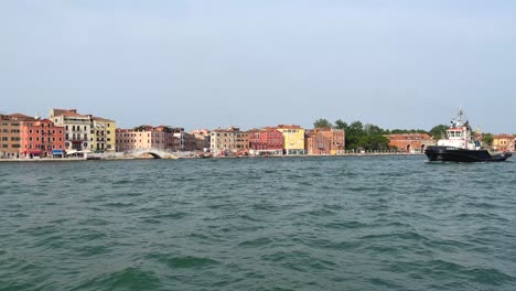 Tug-Boat-Passing-By-In-Front-Of-Colorful-Venetian-Buildings-In-Venice,-Italy