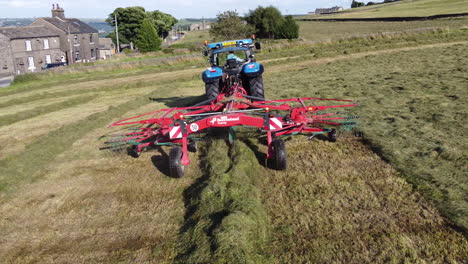 Sobrevuelo-Aéreo-De-Un-Tractor-Recogiendo-Heno-En-Una-Fila