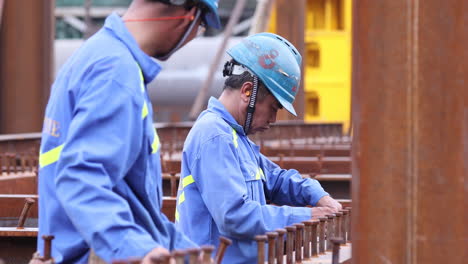 Stahlarbeiter,-Die-Messungen-An-Der-Metallstruktur-Einer-Brücke-Im-Freien-Markieren