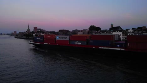 Contenedor-De-Carga-De-Bolero-Que-Transporta-Un-Barco-En-Oude-Maas-Contra-El-Cielo-Rosa-Del-Atardecer