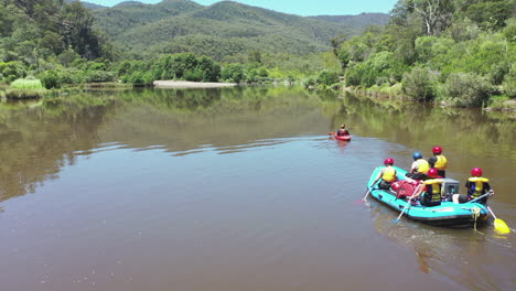 Antenne:-Rafting-Gruppe-Unter-Führung-Eines-Kajakfahrers-Nähert-Sich-Sandstrand-Am-Linken-Fluss