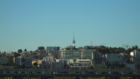 N-Seoul-Tower-or-Namsan-Tower-or-YTN-behind-Yongsan-district-buildings-on-Namsan-Mt-on-bright-cloudless-sky-background-copy-space