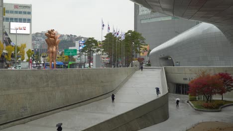 People-Walking-Near-Dongdaemoon-Design-Plaza-On-A-Rainy-Day-In-Seoul,-South-Korea