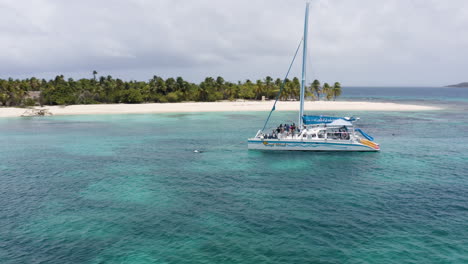 AERIAL---People-at-a-boat-party,-Cayo-Lobos,-Fajardo,-Puerto-Rico,-spinning-shot