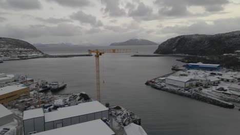 Malerischer-Blick-Auf-Die-Stadt-Mit-Häusern,-Gebäuden-Und-Einem-Kaikran,-Der-Im-Winter-In-Skjervøy,-Nordnorwegen,-Mit-Frischem-Schnee-Bedeckt-Ist