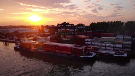 Gantry-Crane-Lifting-And-Loading-Intermodal-Container-Into-Cargo-Ship-At-Port-Of-Ridderkerk-In-Netherlands-During-Golden-Hour