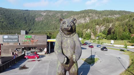 Enorme-Estatua-De-Oso-Fuera-Del-Parque-De-Osos-En-Hallingdal-Noruega---Antena-En-Movimiento-Hacia-Arriba-Con-Thon-Hotel-Bjorneparken-En-Segundo-Plano.