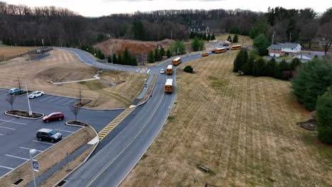 Fleet-of-yellow-school-busses-leave-district-grounds-in-USA