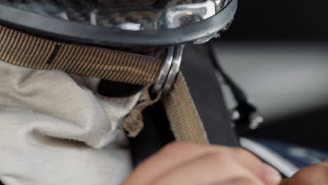 Racing-driver-tightening-the-chin-strap-of-his-crash-helmet