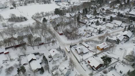 Nach-Unten-Gerichtete-Luftaufnahme,-Die-Einen-Bus-Verfolgt,-Der-Im-Winter-Tagsüber-Auf-Schneebedeckten-Straßen-Im-Wohngebiet-Von-Pitkämäki-Fährt