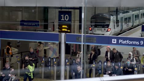 Pasajeros-Que-Salen-De-Las-Barreras-De-Boletos-Después-De-Llegar-Del-Tren-A-La-Estación-De-Kings-Cross