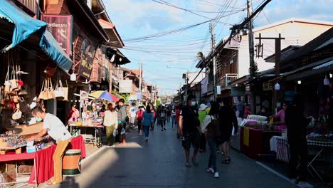 Verkäufer,-Die-Ihre-Waren-Entlang-Der-Fußgängerstraße-In-Chiang-Khan,-Loei,-Ausstellen,-Während-Touristen-Sich-Umsehen,-Um-Etwas-Zu-Kaufen-Und-Zu-Essen,-Thailand