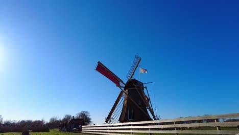 Vista-Del-Molino-De-Viento-Giratorio-Tradicional-En-El-Parque-De-Vacaciones-Molenwaard-Contra-El-Cielo-Azul-Soleado