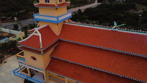 Buddhist-shrine-near-Phan-Thiet-city,-Vietnam,-aerial-view-at-sunset