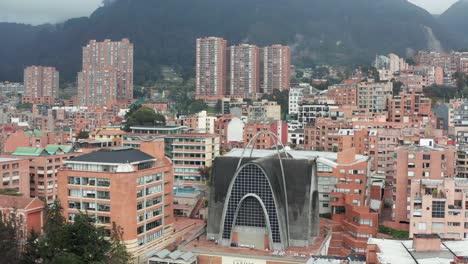 Aerial-forwarding-shot-over-Bogota,-the-capital-and-largest-city-in-Colombia-with-the-view-of-mountain-range-in-the-background-on-a-cloudy-day