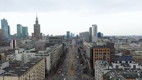 Vista-Aérea-Del-Tráfico-En-La-Calle-Marszałkowska-En-La-Nublada-Varsovia,-Primavera-En-Polonia---Reversa,-Tiro-Con-Drones