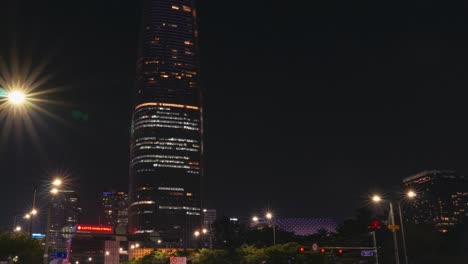 Tilt-up-timelapse-of-Lotte-World-Tower-Mall-from-busy-street-traffic-on-crossroads-in-Seoul-city,-South-Korea