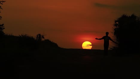 Hombre-Caminando-Solo-Por-La-Carretera-De-La-Ciudad-De-Diu-De-La-India-Contra-El-Sol