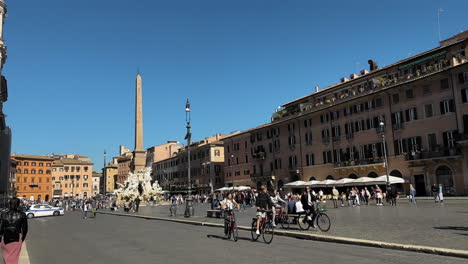 Zeitlupenaufnahme-Von-Passanten-Und-Radfahrern-Mit-Dem-Fahrrad,-Die-Im-Sommer-über-Die-Piazza-Navona-In-Rom-Fahren