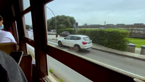 Commuter's-Viewpoint-Of-The-Public-Roadway-And-Other-Passengers-Inside-A-Locomotive-Transport-In-Porto,-Portugal-During-Pandemic