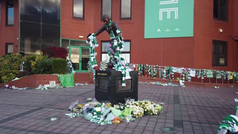 Weitwinkelaufnahme-Der-Mit-Schals-Und-Blumen-Bedeckten-Statue-Von-Jimmy-Johnstone