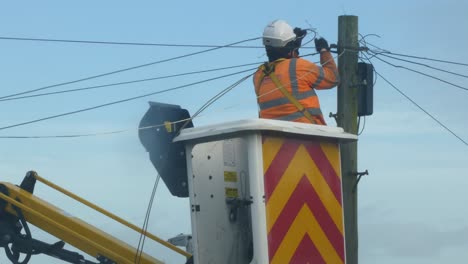 Técnico-De-Telecomunicaciones-Que-Trabaja-En-La-Reparación-Del-Cable-De-Alimentación-Del-Poste-Telefónico-En-La-Cesta-De-La-Grúa-Pluma