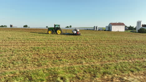 Órbita-Aérea-Baja-Alrededor-Del-Tractor-John-Deere-Tirando-De-La-Sembradora-En-El-Campo