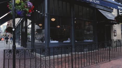 Water-st-cafe-front-entrance-corner-tarp-canopy-medium-wide-angle-panning-up-onto-front-doors-patio-on-sunny-day-downtown-vancouver-BC