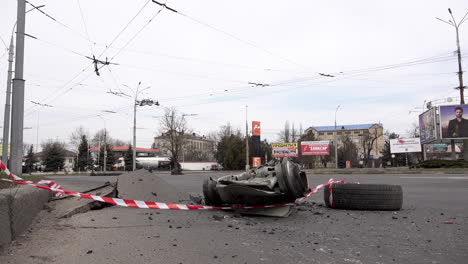 Vehicles-drive-past-a-missile-that-was-shot-down-and-the-wreckage-crashed-and-embedded-into-the-tarmac-of-a-road-during-the-Russian-invasion-of-Ukraine