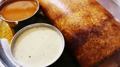 Ein-Verlockendes-Video-Von-Dosa-Mit-Sambar-Und-Weißem-Kokosnuss-Chutney,-Serviert-Auf-Einer-Stahlplatte