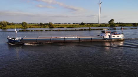 Vista-Lateral-Del-Puerto-Aéreo-Del-Carguero-De-Motor-Interior-Amare-Que-Viaja-A-Lo-Largo-De-Oude-Maas-Contra-Las-Turbinas-Eólicas-En-El-Fondo