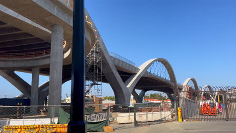 Arches-of-Sixth-Street-Viaduct-Bridge-in-Los-Angeles,-Panning-Down-to-Reveal-Bird-Scooter-on-Sidewalk