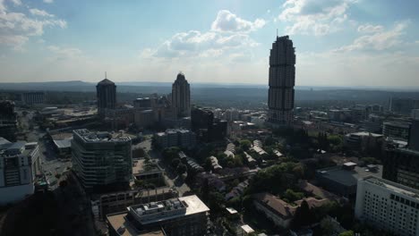 silhouette-of-city-skyline-on-sunny-day-in-Sandton-Johannesburg-South-Africa,-aerial