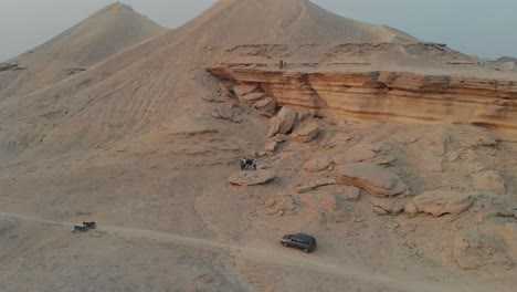 Grupo-De-Amigos-De-Pie-En-Roca-Arenisca-En-El-Paisaje-Desértico-En-Khairpur