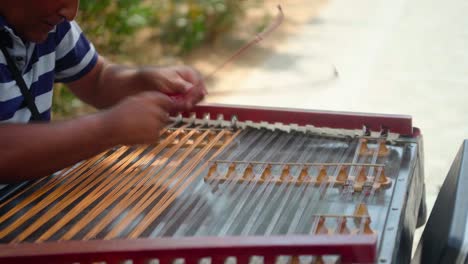 Street-busker-close-up-playing-string-instrument-in-Athens,-Greece