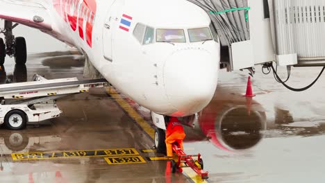 Thai-Lion-Airlines-dock-at-the-concourse-as-they-prepare-for-departure-with-ground-staff-around-on-a-rainy-day-at-Don-Mueang-International-Airport-DMK