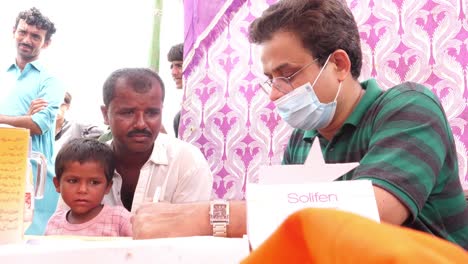 Trabajador-Humanitario-Que-Ayuda-A-Los-Lugareños-Pobres-Durante-El-Campamento-De-Socorro-De-Inundaciones-En-Sindh,-Pakistán