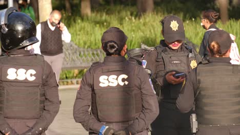 Female-police-officer-Mexico-City-talking-on-cell-phone-wearing-bulletproof-vest