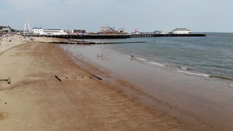 Drone-footage-of-people-enjoying-Clacton-Sea-front-with-the-famous-pier-in-the-background